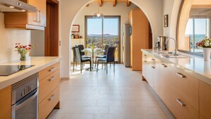 A modern kitchen with an archway leading to a dining area, featuring a view of the outdoors.