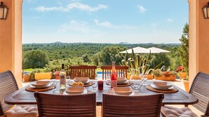 A table set for two with a view of a lush landscape.