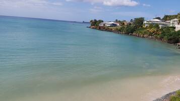 En la playa, playa de arena blanca, camastros y toallas de playa