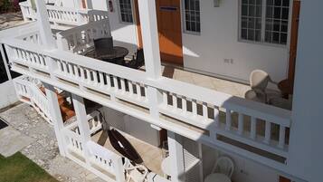 A two-story building with a balcony, outdoor seating, and a tiled patio.