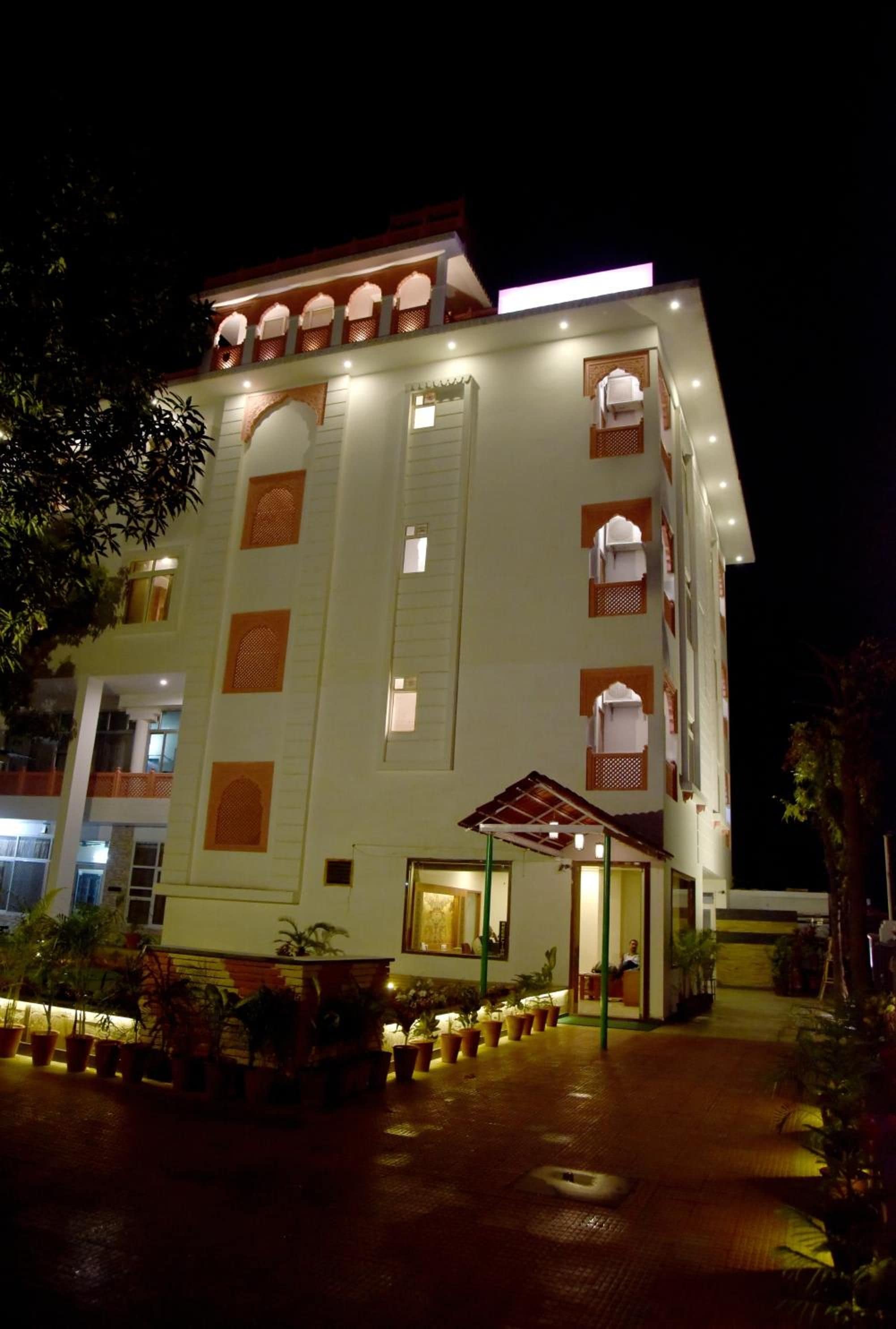A multi-story hotel with a traditional architectural style, featuring arched windows and a covered entrance area.