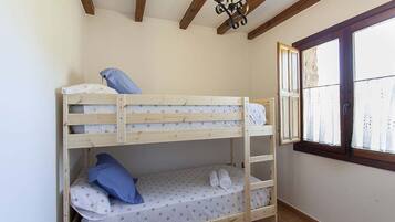 A bunk bed room with a window and wooden beams on the ceiling.
