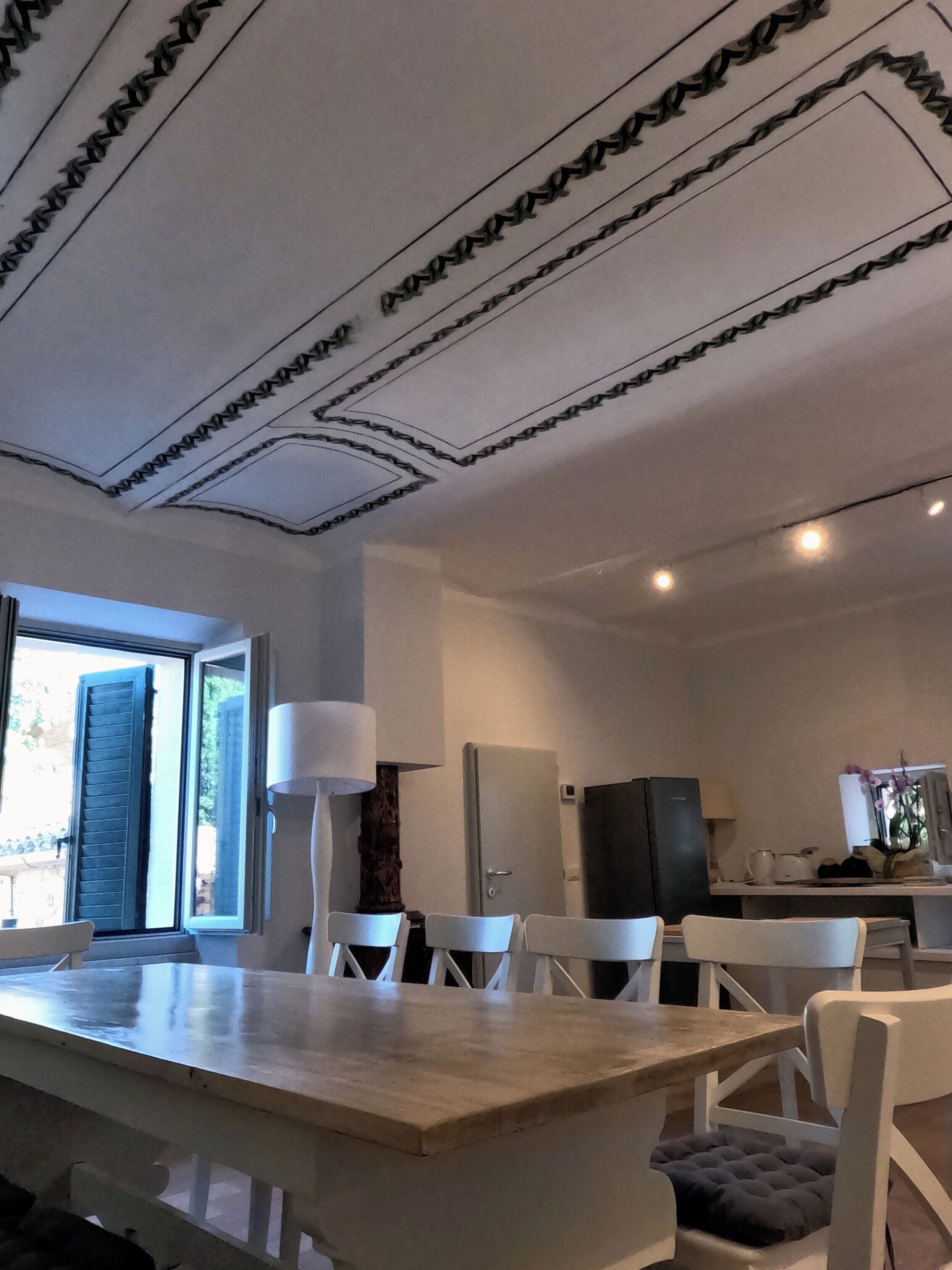Une cuisine moderne avec un îlot central, des chaises blanches et une table à manger.