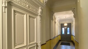 A hallway with ornate white doors, yellow walls, and patterned floor tiles. - MyHappyplace in the middle of Berlin (Berlin)