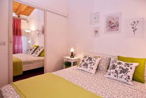 Une chambre à coucher comprenant un lit, une table de chevet, un miroir et des œuvres d’art murales.