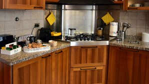 Una cocina con armarios de madera, estufa de acero inoxidable y encimera de granito.