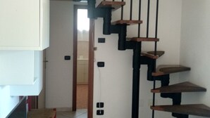 Eine moderne Treppe mit Holzdielen und schwarzen Geländern, die zu einer oberen Etage führt.