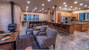 A spacious living area with a fireplace, a dining table, and comfortable seating. - Spectacular Luxury Lodge Home w/Hot Tub, Sauna on Private Lake Sleeps 16-20 Bend (Bend)