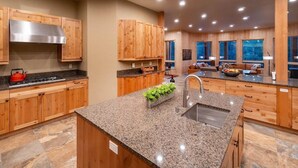 A modern kitchen with wooden cabinets, granite countertops, and a stainless steel range hood. - Spectacular Luxury Lodge Home w/Hot Tub, Sauna on Private Lake Sleeps 16-20 Bend (Bend)