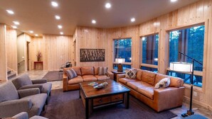 A modern living room with two leather sofas, a coffee table, and a fireplace. - Spectacular Luxury Lodge Home w/Hot Tub, Sauna on Private Lake Sleeps 16-20 Bend (Bend)