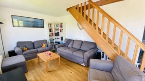 A living room with two grey sofas, a wooden coffee table, and a bookshelf. - CARNAC House 5 rooms - 8/10 persons - Wifi (CARNAC)