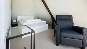 A modern bedroom with a bed, a chair, and a glass table. - CARNAC House 5 rooms - 8/10 persons - Wifi (CARNAC)