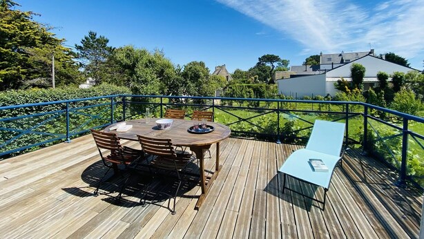 A wooden deck with a round table and chairs, a lounge chair, and a blue railing. - CARNAC House 5 rooms - 8/10 persons - Wifi (CARNAC)