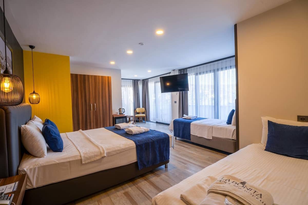 A hotel room with two beds, a TV, a desk, and a chair.