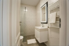 A bathroom with a white sink, a mirror, and a towel rack.