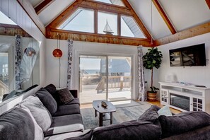 A cozy living room with a large window, a fireplace, and a balcony with a view of the beach. - 25 paces from beach access (Surf City)