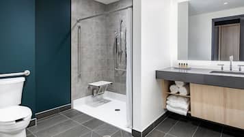 A modern bathroom with a shower, toilet, and vanity.