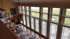 A spacious living room with large windows, a dining area, and a kitchen. - Candy Cove 
Peace and seclusion by the Sea in Maine (Saint George)