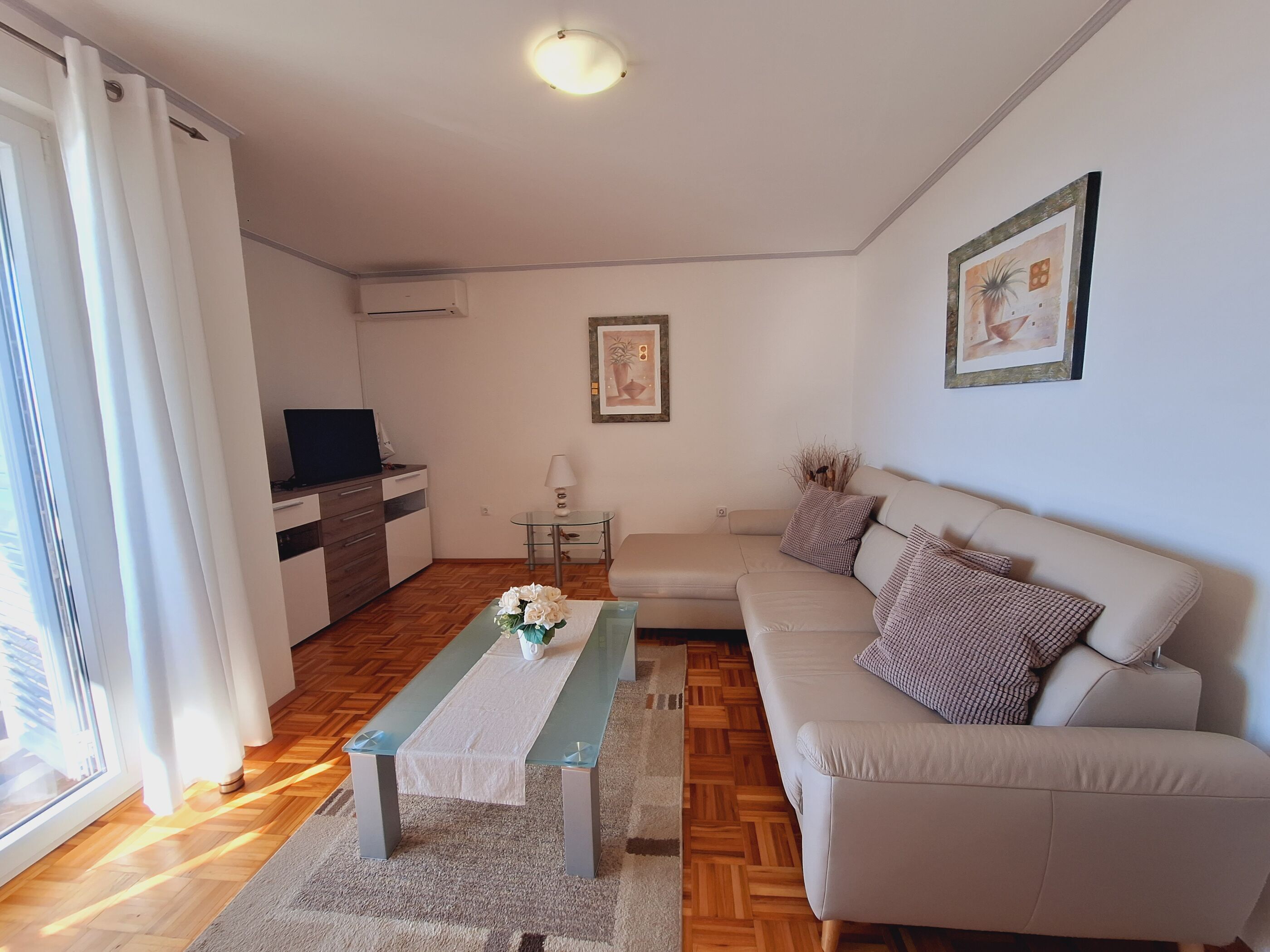 Un salon moderne avec un canapé, une table basse et un téléviseur.