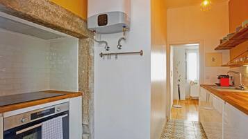 Cozinha com forno embutido, um varal e chão estampado.