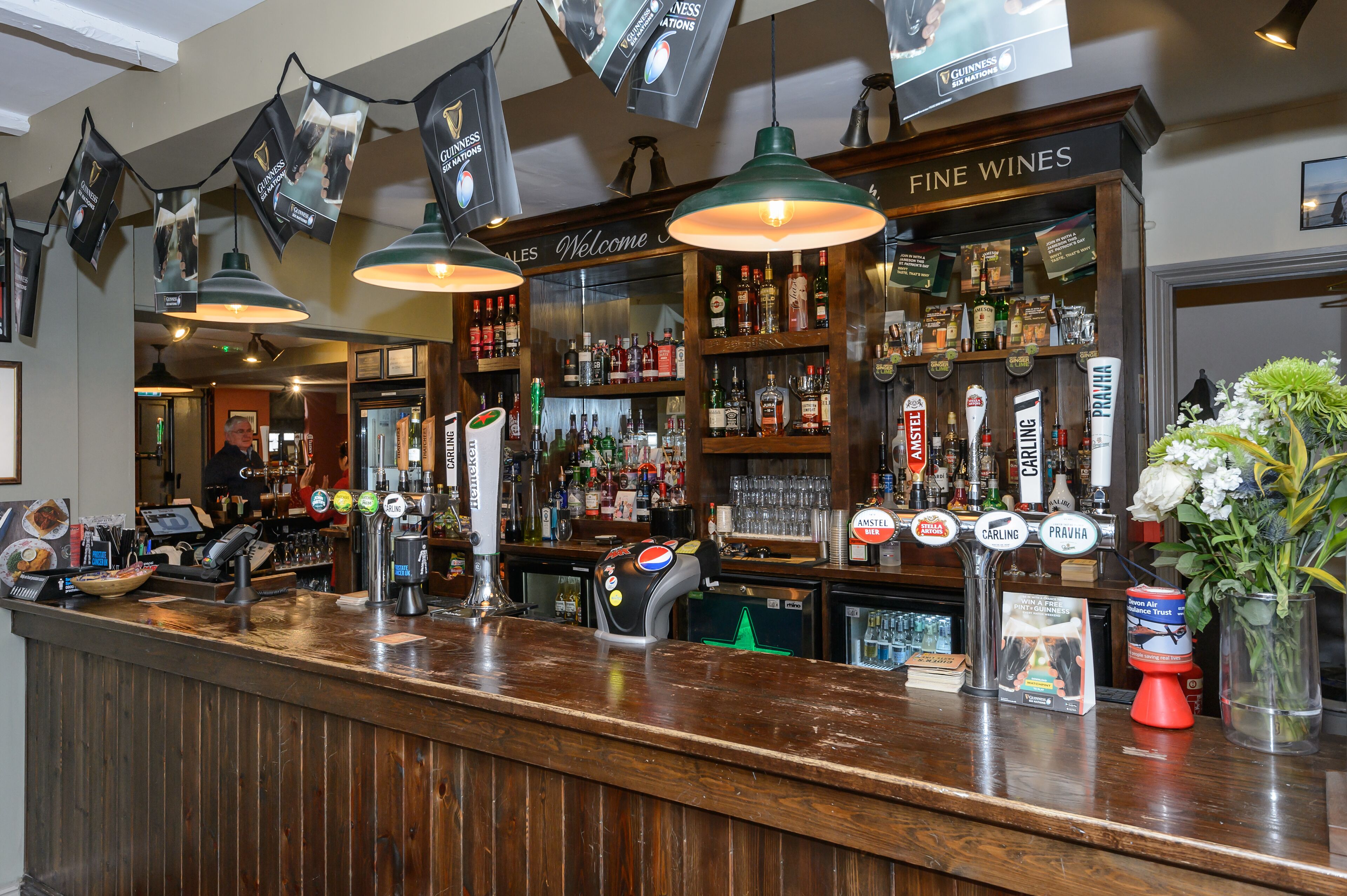 Un espace bar doté d’un comptoir en bois, de plusieurs tireuses à bière et d’un choix de vins fins.