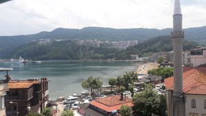 A coastal town with a prominent minaret, a marina, and a hilly backdrop. - Ozyurt Otel Amasra (Amasra)