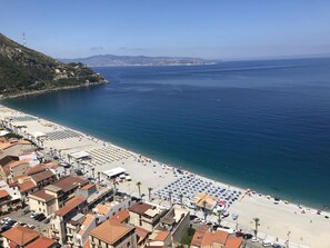 A coastal town with a beach, buildings, and a clear view of the sea.
