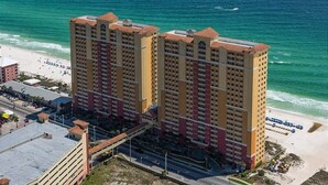 Un grand hôtel à plusieurs étages, situé près d’une plage et offrant une vue dégagée sur l’océan.