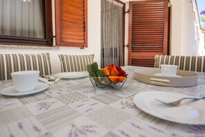 A beautifully set table for two, complete with a floral tablecloth and a single rose.