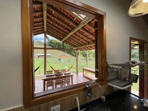 Uma cozinha com uma janela grande que dá para um pátio.