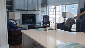 Una cocina con una isla grande, armarios de madera y una chimenea.