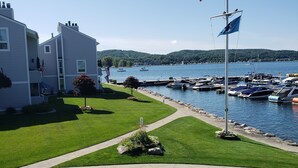 Un puerto deportivo con barcos, un asta con la bandera estadounidense y un edificio con una bandera.