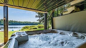 Un bain à remous avec vue sur un lac et une forêt.