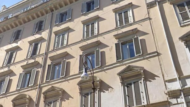 Un edificio de varios pisos con estilo arquitectónico clásico, que presenta ventanas simétricas y detalles decorativos.