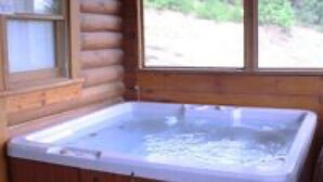 A wooden cabin with a hot tub in the corner. - Dollywood pigeon forge Cabin, Pools, Game Room, Hot tub, 0.5 mile to Parkway (Pigeon Forge)