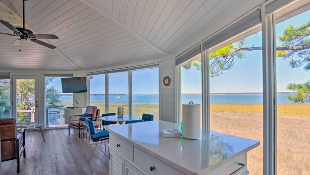 A spacious kitchen with large windows offering a view of the sea and a grassy field. - Ocean-View Treetop Escape w/ Fire Pit! (Hilton Head)