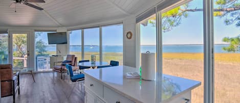 Una cocina amplia con ventanas grandes que ofrecen vista al mar y a un campo cubierto de césped.