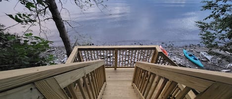 A wooden staircase leading to a dock by a calm lake.