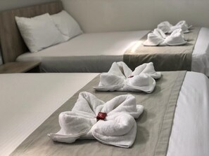 A hotel room with neatly arranged towels on the beds. - Hotel Pradera Plaza (Dosquebradas)
