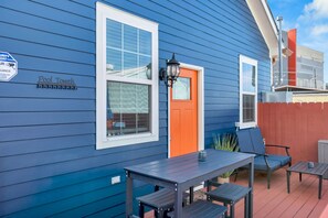 A blue house with a sign that reads 'Pool Towel' and a red door.