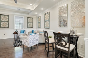 A spacious dining area with a wooden table and chairs, a patterned rug, and decorative wall art. - Creole Queen with Pool, 5 bedrooms with off-street parking (New Orleans)