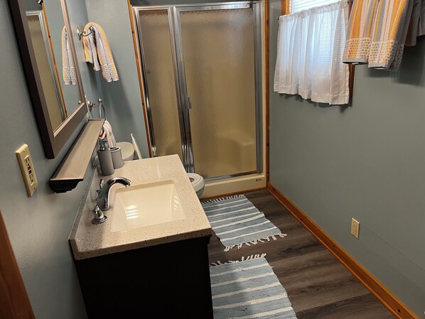 A bathroom with a sink, mirror, towel rack, and shower. - Book NOW! Dog friendly, partial Ocean View, 4x4 Area, Cozy Beach cottage . (Corolla)