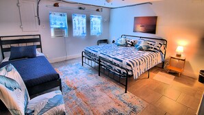 A bedroom with two beds, a ceiling fan, a window with starfish decals, and a nightstand with a lamp. - Galveston Getaway/Cruise, Fishing, Contractors & Beach (Galveston)