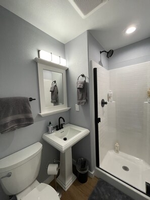 Tina con regadera, toallas, jabón, shampoo