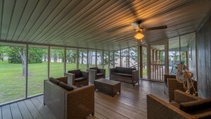 Un espacio al aire libre techado con muebles de mimbre y un ventilador de techo.