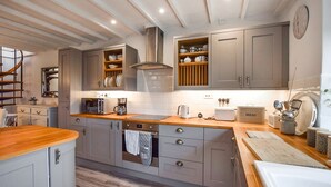 A modern kitchen with grey cabinets, a wooden countertop, a built-in oven, and a coffee maker. - Suncroft - sleeps 8 guests  in 3 bedrooms (Banbury)