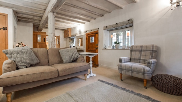 A living room with a sofa, armchair, and a small table.