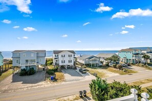 Houses line the sandy beach, offering ocean views from their front porches.