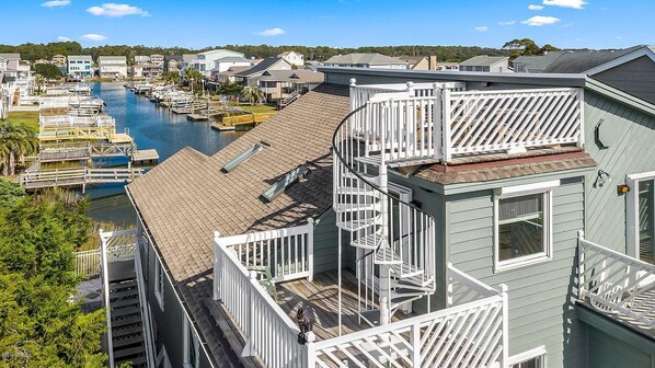 A residential area with a dock and boats, a staircase, and a view of the water.