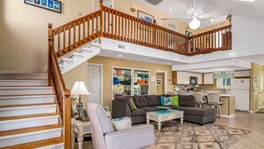 A spacious living area with a staircase, a dining area, and a kitchen. - Second Row, 4 Bedroom/3 Bath Home w/ Private Pool and Dock. Sleeps 10 (Holden Beach)